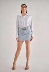 Minifalda de jean celeste con rayas verticales de strass y cinturón con hebilla metálica.