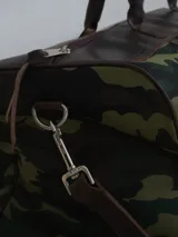 Bolso de lona azul con detalles en cuero marrón, doble asa de mano y correa bandolera ajustable. Incluye un neceser haciendo juego con cierre y logo de caballo bordado.