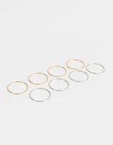 Set de seis pulseras rígidas de metal, tres plateadas y tres doradas.