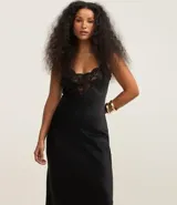Vestido midi negro de satén con breteles finos y escote en V con detalle de encaje en el busto.