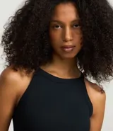 Blusa sin mangas color marrón, confeccionada en tejido rib con textura. Presenta cuello halter que resalta los hombros.