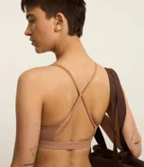 Top deportivo color marrón claro, confeccionado en microfibra lisa, con breteles finos cruzados en la espalda y espalda abierta.