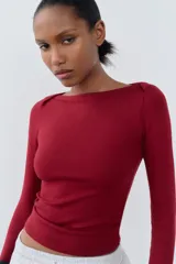 Camiseta negra de algodón con cuello barco y mangas largas.