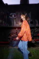 Camisa de seda color naranja con estampado floral, corte amplio, mangas abullonadas y frunce en hombros y espalda.