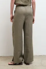 Pantalón color arena, de corte recto y tiro alto, confeccionado en lino.