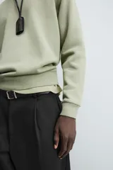 Sudadera verde militar de algodón con interior de rizo, corte relaxed fit, cuello redondo y mangas largas con puños y ruedo acanalados.