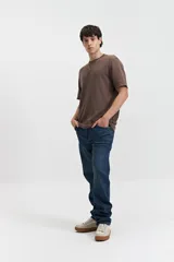 Remera marrón de manga corta con cuello redondo, textura acanalada y lettering estampado en el pecho.