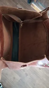 Bolso tipo tote de cuero color marrón, con doble asa de hombro y cierre superior.