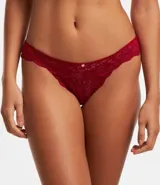 Bombacha bikini hilo color rosa con encaje floral y moña en la cintura.