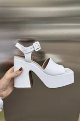 Sandalia de cuero color blanco con plataforma y tacón de 10 cm, diseñada para comodidad y estilo.