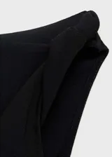 Top negro con escote drapeado asimétrico y sin mangas.