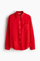 Camisa roja de lino con cuello clásico, botones frontales y bolsillo en el pecho.