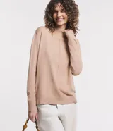 Blusa color beige confeccionada en tejido de punto, con cuello alto y mangas largas.