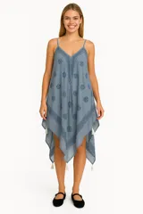 Vestido corto azul con estampado de flores y diseño asimétrico con terminaciones en punta y borlas.