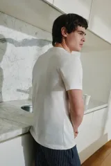 Conjunto de pijama para hombre, compuesto por una remera blanca de manga corta y un pantalón largo azul marino a rayas verticales blancas.