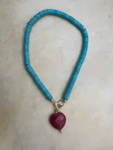 Collar de cuentas de colores con dije de corazón.