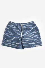 Short de baño blanco con estampado de hojas en tonos naranja, verde y rosa. Cuenta con cintura elástica, cordón ajustable, bolsillos laterales, suspensor interno y logo estampado.