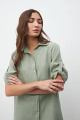Vestido camisero verde con cuello clásico, abotonado al frente y mangas 3/4 con trabillas.