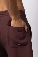 Short de baño color bordó, de corte recto y largo medio, con cordón de ajuste blanco en la cintura y pequeño parche con logo en la pierna derecha.