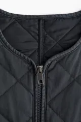Campera corta acolchada color gris oscuro con cuello redondo, cierre frontal con cremallera y bolsillos laterales. Diseño con patrón de rombos. Forrada.