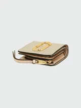 Billetera mini compacta Marc Jacobs color beige con logo dorado en el frente y correa de muñeca rosa.