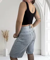 Musculosa ajustada de tejido acanalado (morley), con escote redondo y bordes ondulados en el ruedo. Disponible en colores beige, blanco y negro.