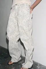 Jeans tiro medio de calce holgado, color crudo con estampado floral en tonos grises.
