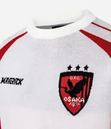 Camisa masculina de manga corta, color blanco con detalles en rojo en los hombros y mangas. Presenta el logo "MAVERICK" en el pecho izquierdo y un escudo con un ave y la palabra "OSAKA" en el pecho derecho.