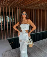 Vestido tejido strapless color blanco, con detalles calados y falda larga con flecos. Incluye short.