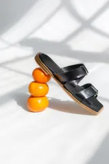 Sandalias bajas color camel con tiras anchas entrelazadas formando un nudo.