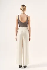 Pantalón palazzo negro de tiro alto, confeccionado en cupro y viscosa. Cuenta con bolsillos diagonales laterales, bolsillos ojal falsos en la espalda y cierre lateral invisible.