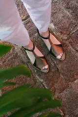 Sandalias de cuero color blanco con detalles dorados, taco bajo de madera y tira con hebilla al tobillo.