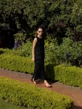 Vestido midi de tejido de punto con lurex color borgoña, corte recto, sin mangas y con tajos laterales.