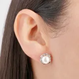 Aros tipo botón con perla central y borde plateado con diseño retorcido.