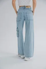 Pantalón de jean celeste, de tiro alto y corte ancho, con bolsillos cargo laterales y cierre con cremallera en los tobillos.