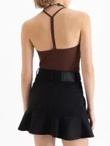 Top de punto color marrón, ajustado al cuerpo, con escote en V pronunciado y tirantes finos que se unen en la espalda.