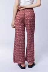 Conjunto de pantalón palazzo con aberturas laterales y kimono largo con estampado geométrico en tonos rosa y beige. Incluye un top blanco de algodón.