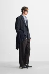 Pantalón de vestir negro de corte recto, con cintura elástica, pliegues frontales, bolsillos laterales y traseros.