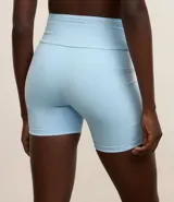 Conjunto deportivo celeste compuesto por un top con breteles anchos y detalle de malla en el escote, y un short de calce ajustado con bolsillos laterales.