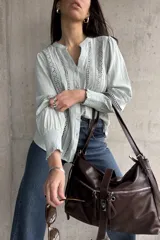 Camisa celeste con bordado inglés, cuello mao y mangas largas abullonadas con puños elásticos.