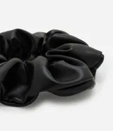 Scrunchie mediana de poliuretano negro, sin estampa.