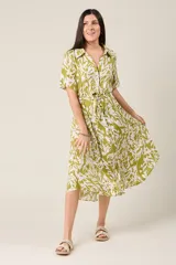 Vestido midi con estampado de hojas en verde y blanco, cuello camisero, botones frontales, manga corta y cinturón.