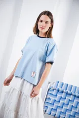 Remera azul marino de algodón con cuello redondo blanco y mangas cortas con bordado blanco.