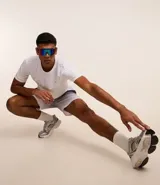 Bermuda deportiva masculina con cintura elástica, cordón interno de ajuste y forro de malla. Diseño con cuadros difuminados en degrade de gris oscuro a blanco.