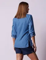 Blusa celeste de lyocell con cuello a la base con solapa, escote en V y abertura central con botones. Manga 3/4 regulable con presilla y botón.