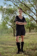 Vestido corto tejido en lurex negro con cuello redondo y mangas cortas.