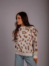 Sweater de punto color crema con estampado animal print color marrón.