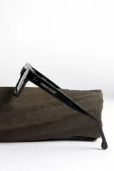 Lentes de sol negros con marco rectangular y lentes verdes.