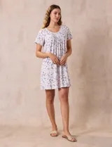 Camisón corto negro con lunares blancos, de tejido suave y escote redondo con detalle plisado y moño blanco.