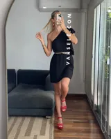 Vestido corto color verde lima, con escote asimétrico a un hombro, volado en el hombro y elástico en el borde superior.